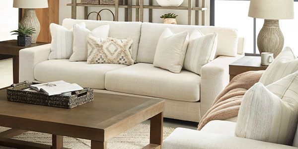Ivory sofas with patterned cushions, a wood coffee table and sculptural table lamps.