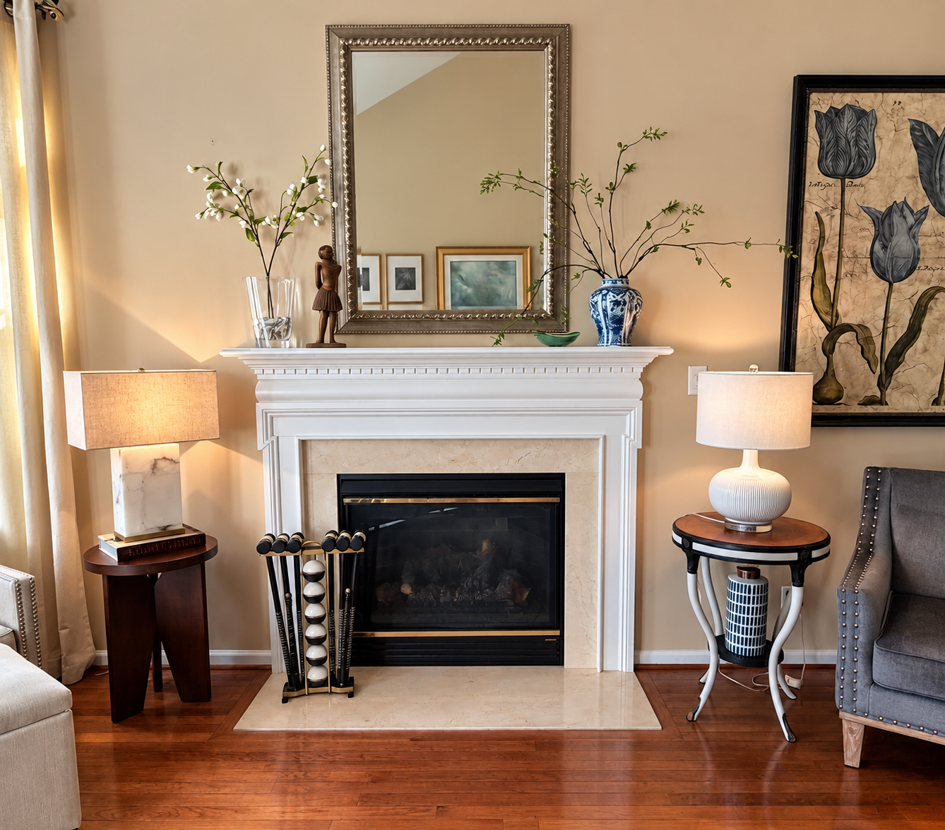 A white fireplace mantel with a small repainted Degas-inspired statue, framed photographs, vases and a mirror above.