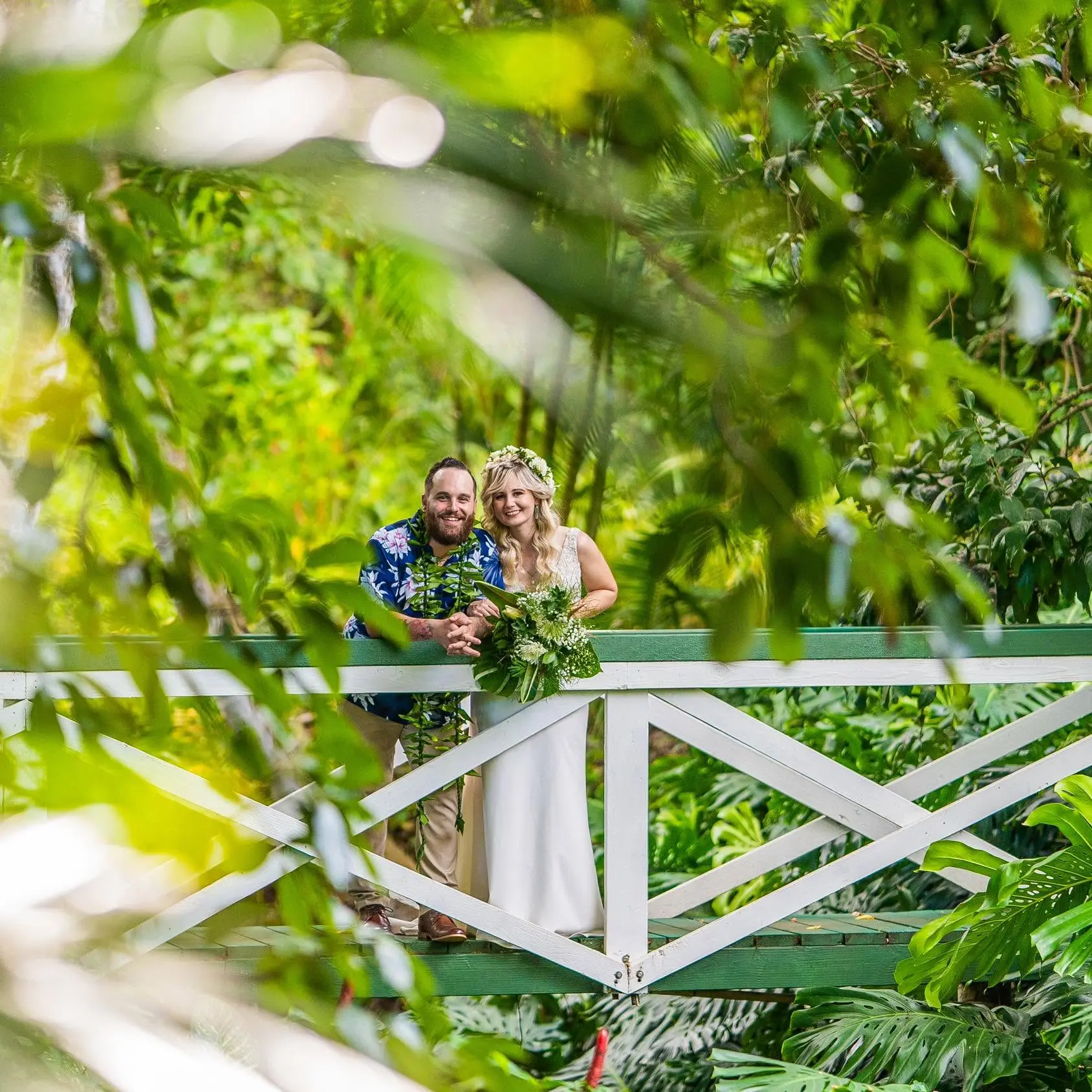 Gregg and Sarah standing together on a garden bridge on their wedding day.