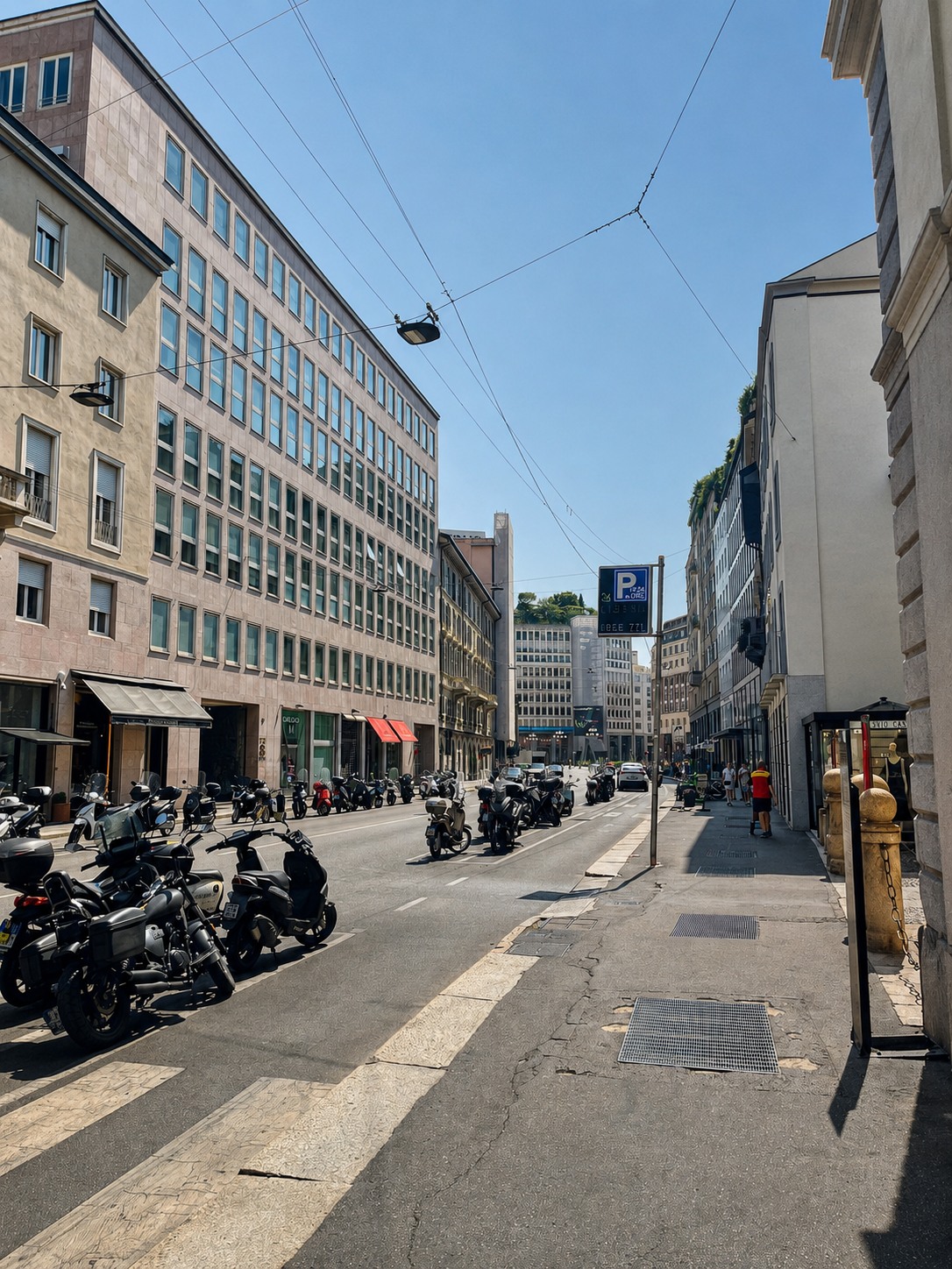 Sunlit central Milan street with scooters and modern architecture.