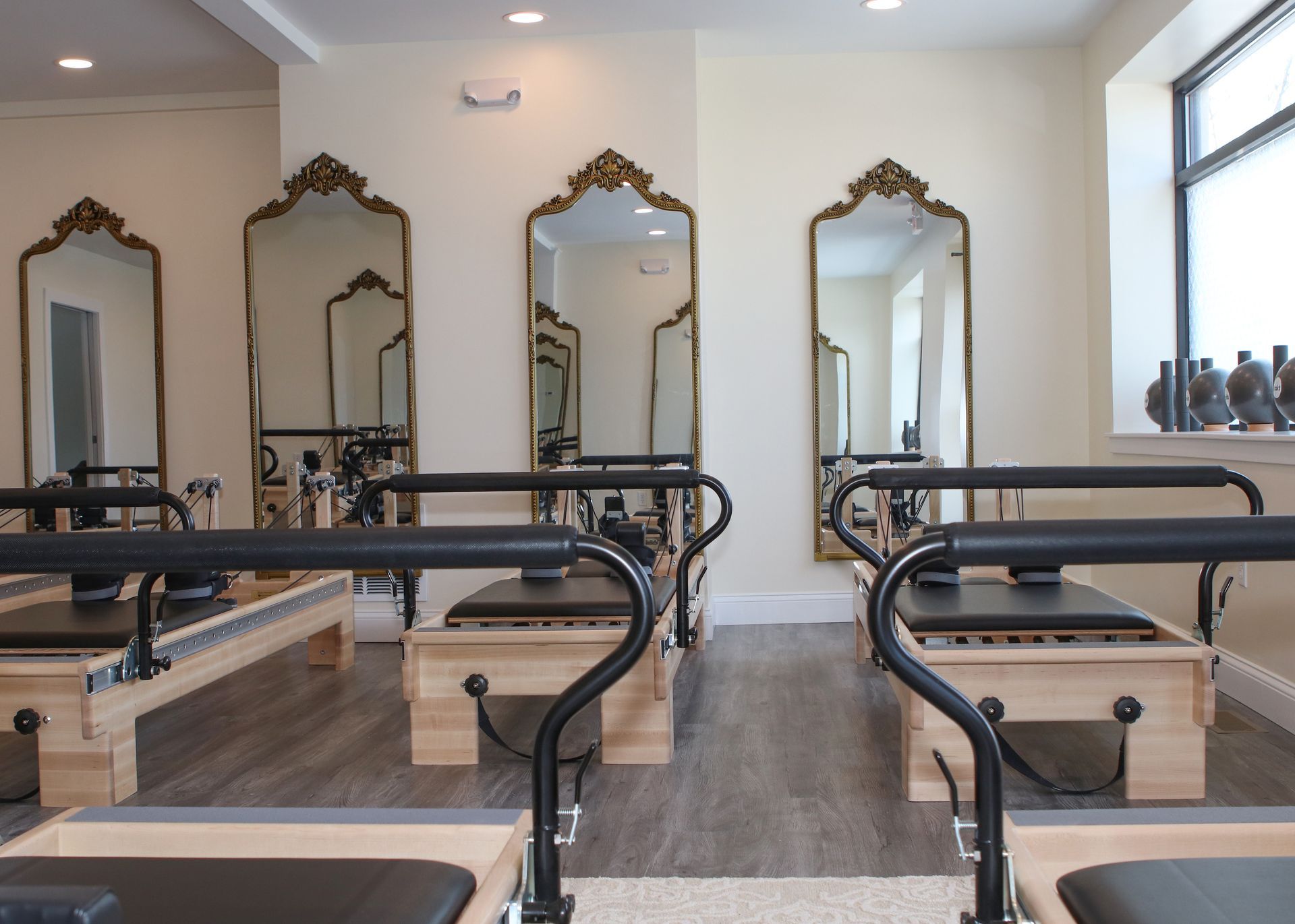 The reformer room at Bella Forma Pilates, a colonnade of Balanced Body machines framed by ornate gold-leaf mirrors