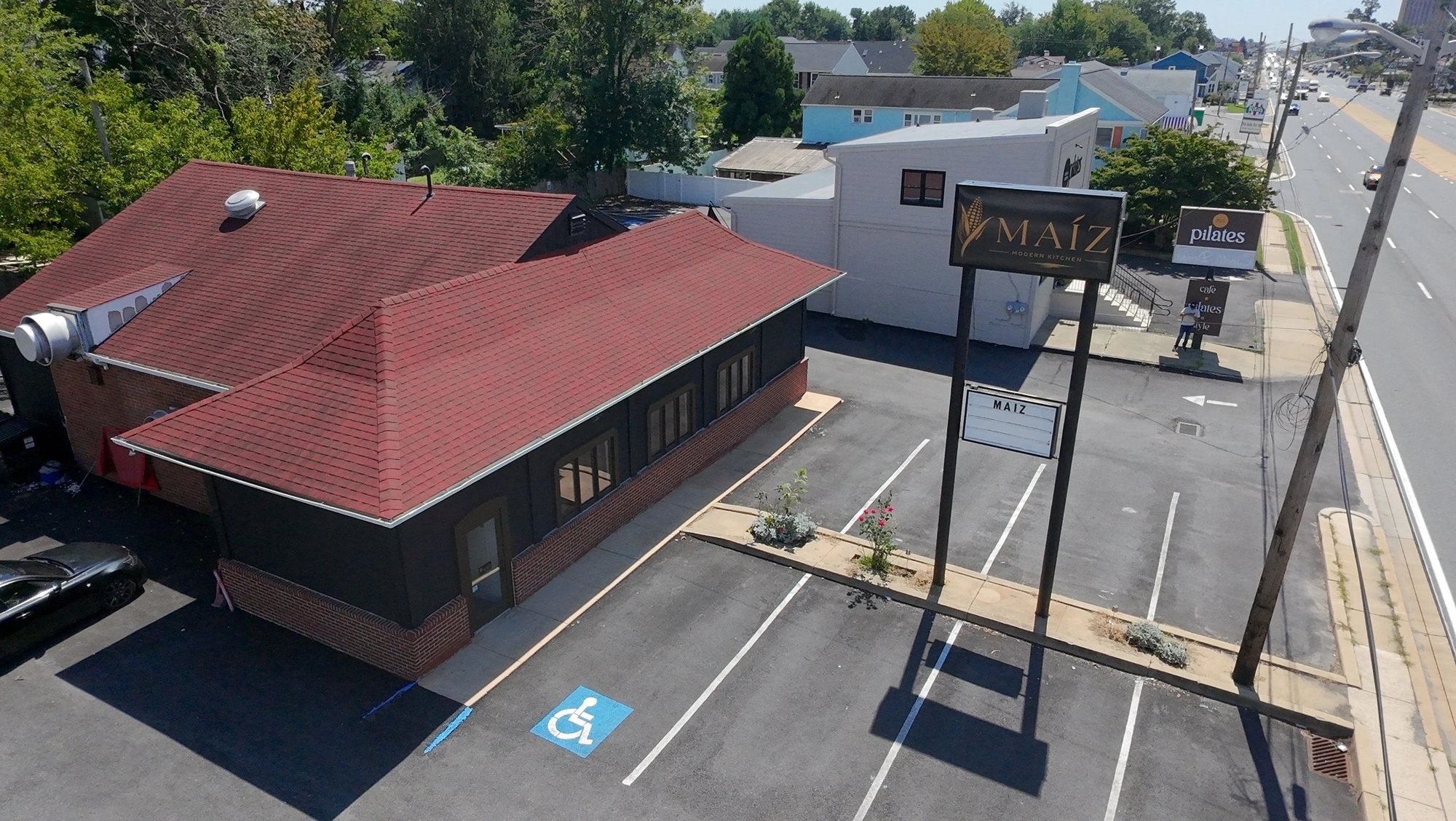 Aerial view of the MAIZ building on Concord Pike, with its red roof, sign and parking lot.